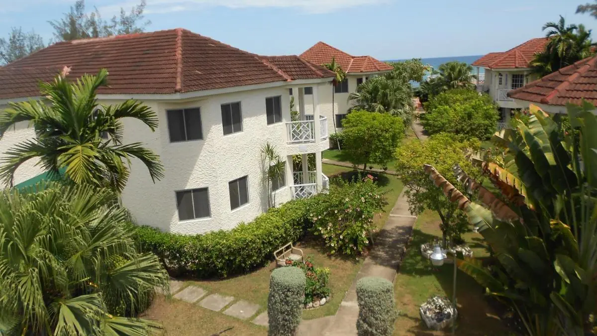 The buildings of Pipers Cove Resort among gardens and palm trees